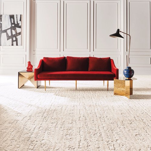 A red couch on a white capet in the middle of the room from Carpet Plus in Worthington